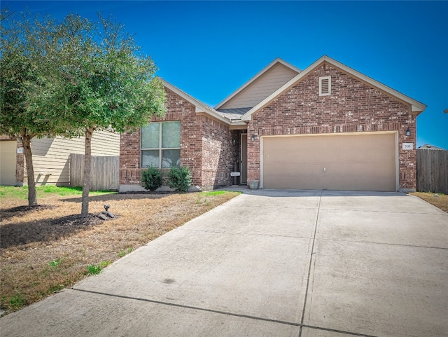 705 Estes Park, Taylor, TX 76574 - view of front facade featuring driveway, brick siding, and an attached garage