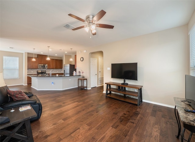 705 Estes Park, Taylor, TX 76574 - living area with arched walkways, a ceiling fan, and dark wood-style floors