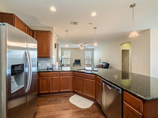 705 Estes Park, Taylor, TX 76574 - kitchen with stainless steel appliances, arched walkways, brown cabinets, and recessed lighting