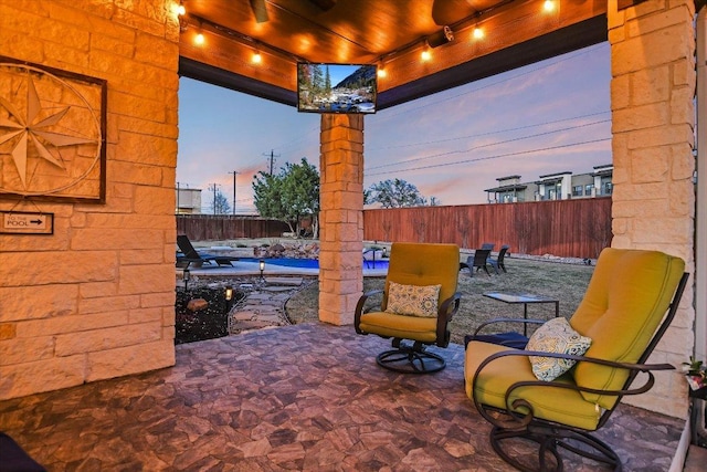 patio terrace at dusk featuring a fenced backyard