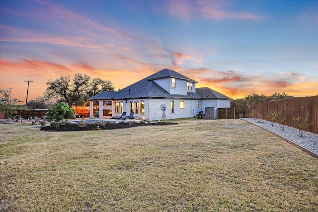 back of property featuring a lawn, a pool, a fenced backyard, and a patio area