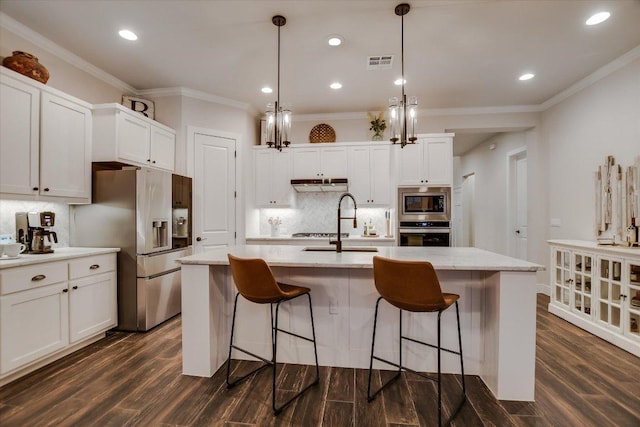 kitchen with a kitchen breakfast bar, visible vents, stainless steel appliances, and backsplash