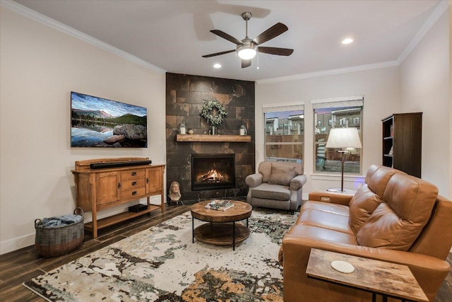 living room with baseboards, wood finished floors, a ceiling fan, and crown molding