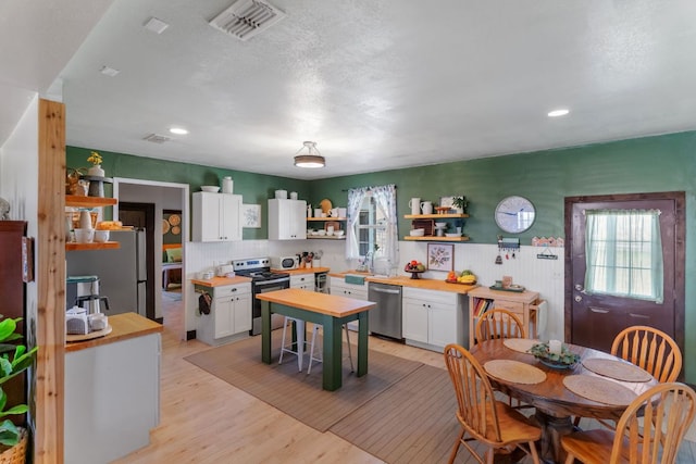 130 Holbox Dr, Del Valle, TX 78617 - kitchen with appliances with stainless steel finishes, open shelves, plenty of natural light, white cabinetry, and recessed lighting