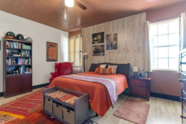 130 Holbox Dr, Del Valle, TX 78617 - bedroom with wood finished floors, a ceiling fan, and wooden walls