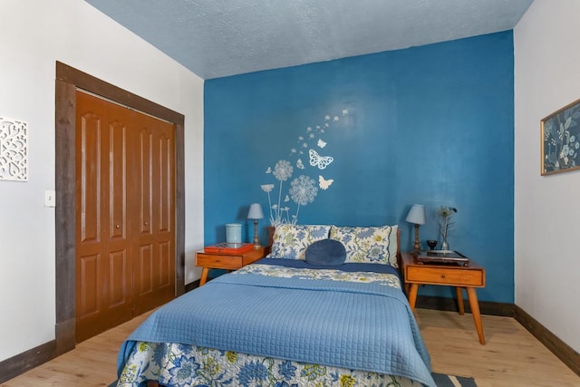 130 Holbox Dr, Del Valle, TX 78617 - bedroom with wood finished floors and a textured ceiling