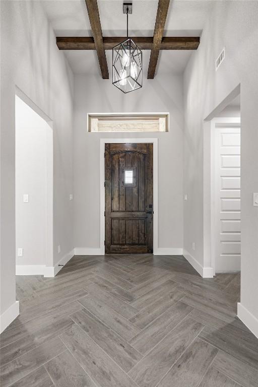 122 Liberty Bell Ln, Fischer, TX 78623 - entrance foyer featuring coffered ceiling, baseboards, beamed ceiling, and a chandelier