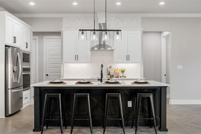 122 Liberty Bell Ln, Fischer, TX 78623 - kitchen with appliances with stainless steel finishes, a kitchen bar, wall chimney exhaust hood, light countertops, and white cabinets