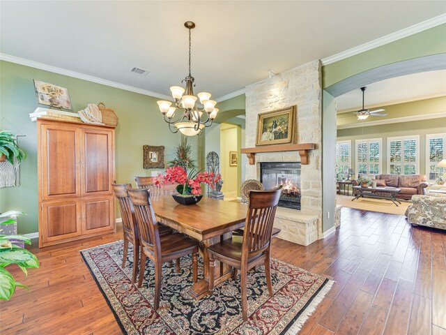 217 Piedmont Hills Pass, Austin, TX 78732 - dining room featuring crown molding, arched walkways, ceiling fan, a fireplace, and wood-type flooring