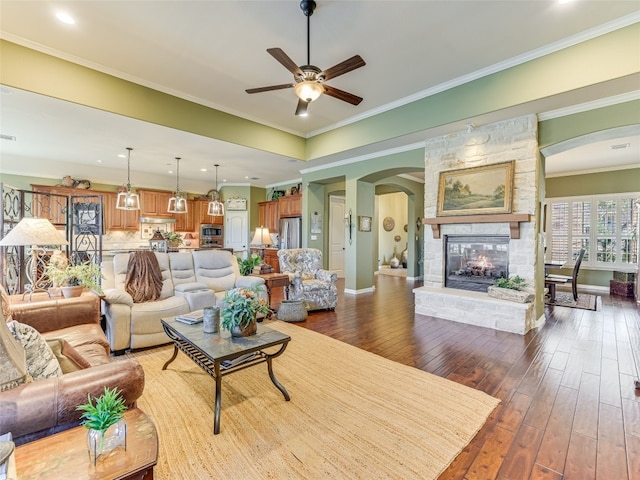 217 Piedmont Hills Pass, Austin, TX 78732 - living area with arched walkways, hardwood / wood-style flooring, a fireplace, ceiling fan, and baseboards