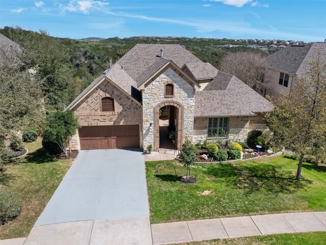 217 Piedmont Hills Pass, Austin, TX 78732 - french country home with stone siding, a front lawn, a garage, concrete driveway, and a shingled roof