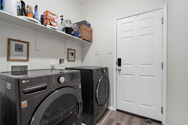 laundry area with laundry area, independent washer and dryer, and wood finished floors
