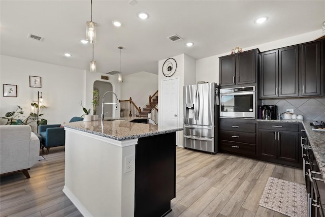 kitchen featuring visible vents, appliances with stainless steel finishes, light wood-style floors, and a sink