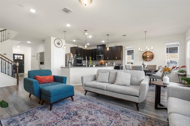 1128 Hemlen Cv, Leander, TX 78641 - living room with stairway, light wood-style floors, recessed lighting, and a chandelier