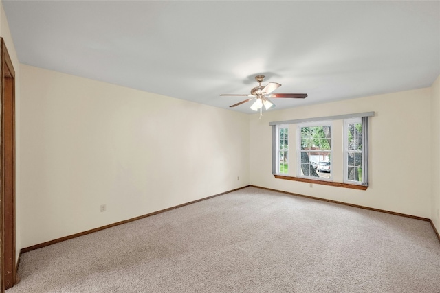 spare room with baseboards, a ceiling fan, and light colored carpet