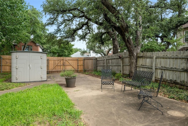 view of patio with a fenced backyard, a storage shed, and an outbuilding