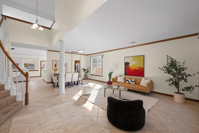 living room with light tile patterned flooring, baseboards, decorative columns, and stairs