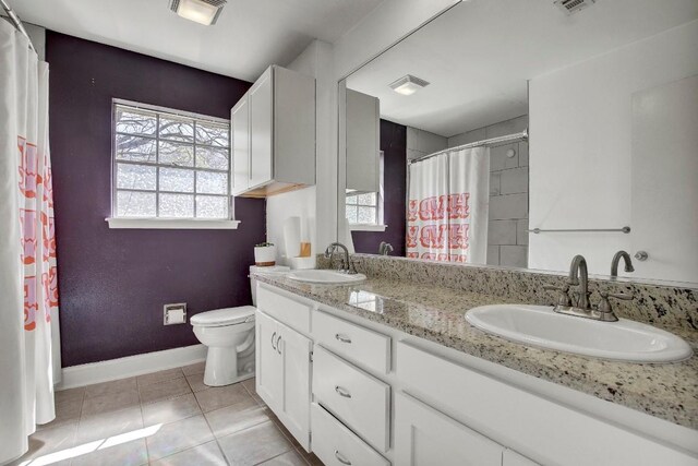 12333 Blue Water Dr, Austin, TX 78758 - bathroom with plenty of natural light, toilet, tile patterned floors, and double vanity
