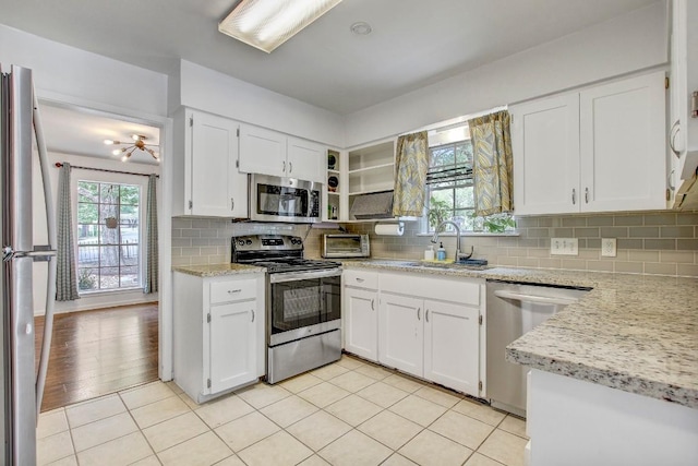 12333 Blue Water Dr, Austin, TX 78758 - kitchen with appliances with stainless steel finishes, healthy amount of natural light, a sink, and white cabinetry