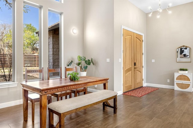 1017 S Quinlan Park Rd, Austin, TX 78732 - dining space featuring a chandelier, wood finished floors, and a high ceiling