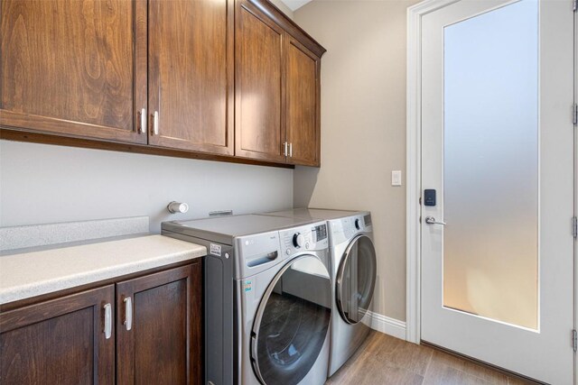 1017 S Quinlan Park Rd, Austin, TX 78732 - laundry area with cabinet space, washing machine and clothes dryer, and light wood-style floors