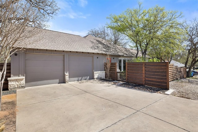 1017 S Quinlan Park Rd, Austin, TX 78732 - view of property exterior with roof with shingles, board and batten siding, driveway, an attached garage, and stone siding