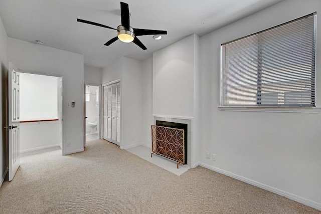 611 E 45th St Unit 15, Austin, TX 78751 - unfurnished living room with a tiled fireplace, carpet flooring, and a ceiling fan