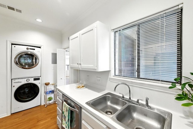 611 E 45th St Unit 15, Austin, TX 78751 - kitchen with stacked washer / dryer, ornamental molding, dishwasher, white cabinets, and light countertops
