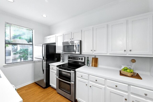 611 E 45th St Unit 15, Austin, TX 78751 - kitchen with appliances with stainless steel finishes, white cabinetry, light countertops, light wood-type flooring, and recessed lighting