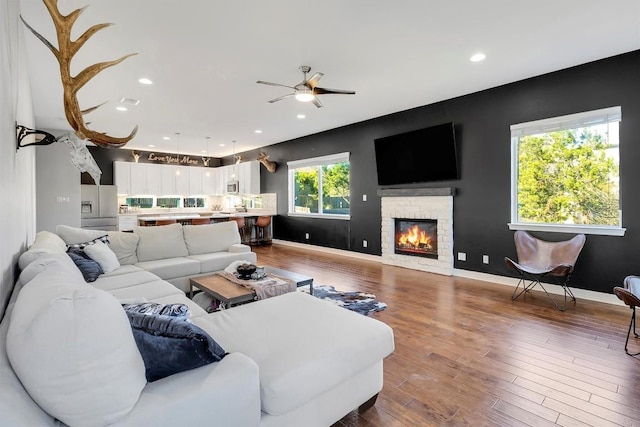 22113 Shotts Dr, Spicewood, TX 78669 - living room featuring a ceiling fan, wood finished floors, a brick fireplace, recessed lighting, and baseboards