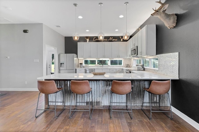 22113 Shotts Dr, Spicewood, TX 78669 - kitchen with appliances with stainless steel finishes, dark wood-type flooring, white cabinetry, decorative backsplash, and recessed lighting