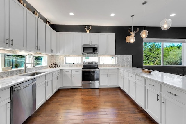 22113 Shotts Dr, Spicewood, TX 78669 - kitchen with appliances with stainless steel finishes, a sink, white cabinets, backsplash, and dark wood-style flooring