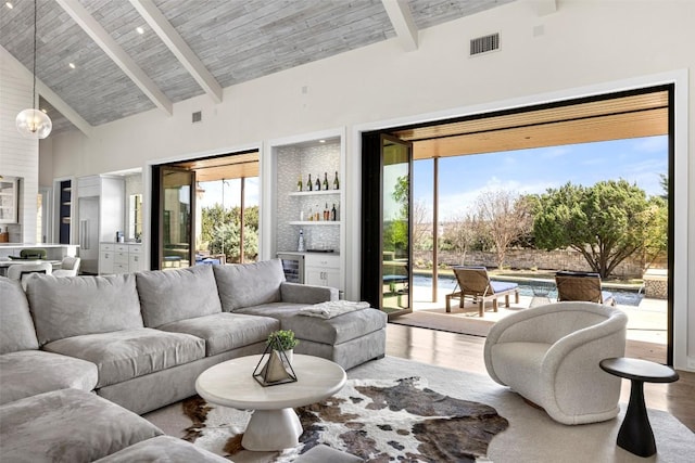 599 Vendemmia Bnd, Austin, TX 78738 - living area featuring a bar, high vaulted ceiling, wood finished floors, a chandelier, and a wood ceiling with exposed beams
