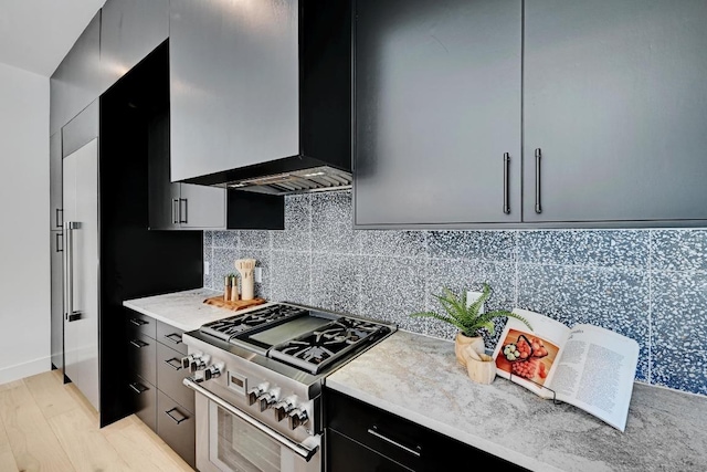 2109 Glendale Pl, Austin, TX 78704 - kitchen with high end stainless steel range, light countertops, dark cabinets, modern cabinets, and tasteful backsplash