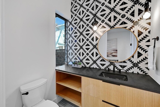 2109 Glendale Pl, Austin, TX 78704 - bathroom with vanity, toilet, tile patterned floors, and backsplash