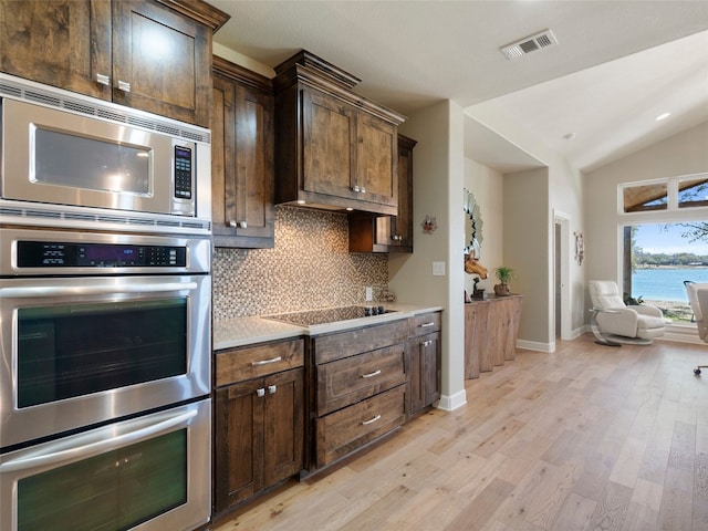 300 E Heron Dr, Marble Falls, TX 78654 - kitchen featuring stainless steel appliances, tasteful backsplash, light wood-style flooring, vaulted ceiling, and light countertops