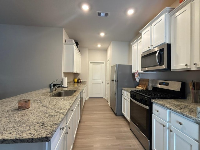 11415 Prairie Walk Dr, Houston, TX 77048 - kitchen with stainless steel appliances, a sink, a peninsula, light wood-type flooring, and recessed lighting