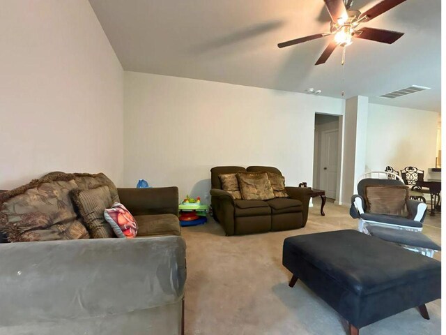 living area with a ceiling fan, light colored carpet, and visible vents
