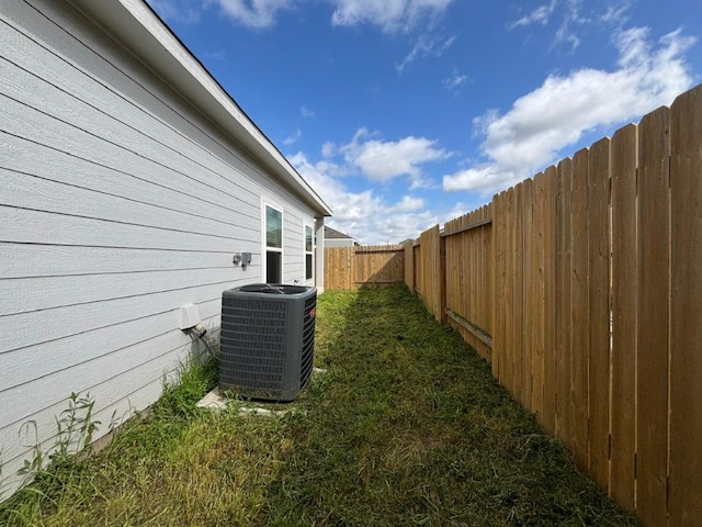 view of yard with central air condition unit and a fenced backyard