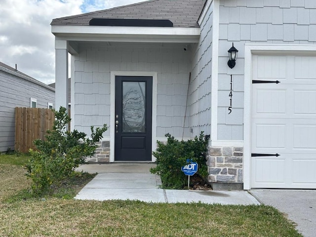 doorway to property featuring stone siding and an attached garage