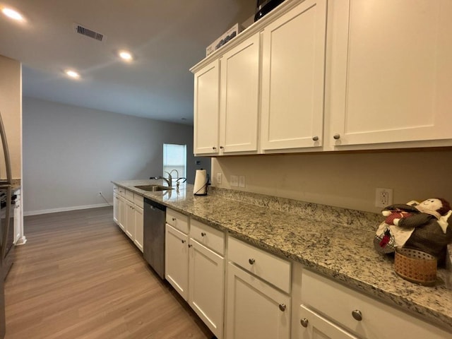 kitchen with visible vents, a sink, stainless steel dishwasher, white cabinetry, and light wood-style floors