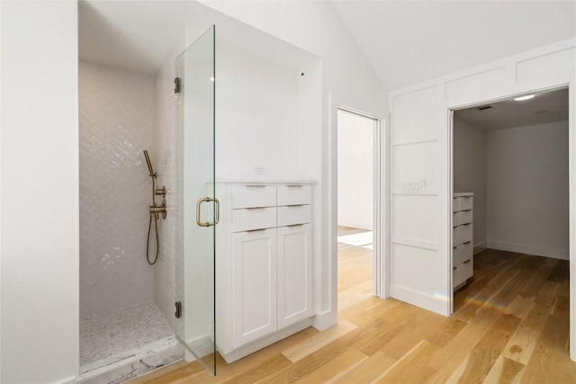 717 Meriden Ln, Austin, TX 78703 - bathroom featuring a shower stall, wood finished floors, and lofted ceiling