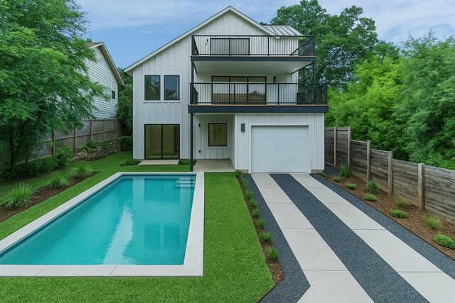 717 Meriden Ln, Austin, TX 78703 - back of property featuring a balcony, board and batten siding, a fenced backyard, and driveway