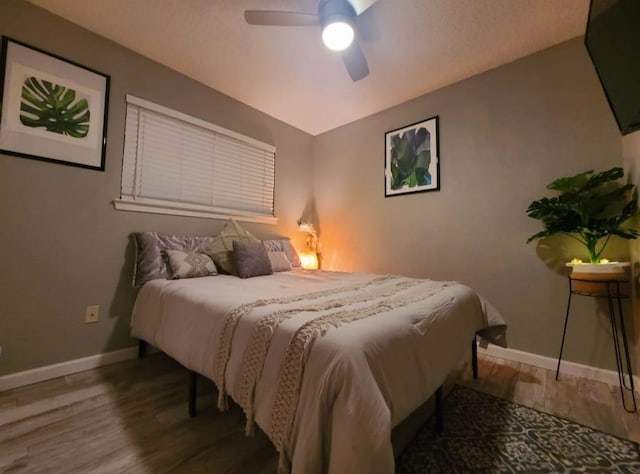 bedroom featuring wood finished floors, baseboards, and ceiling fan