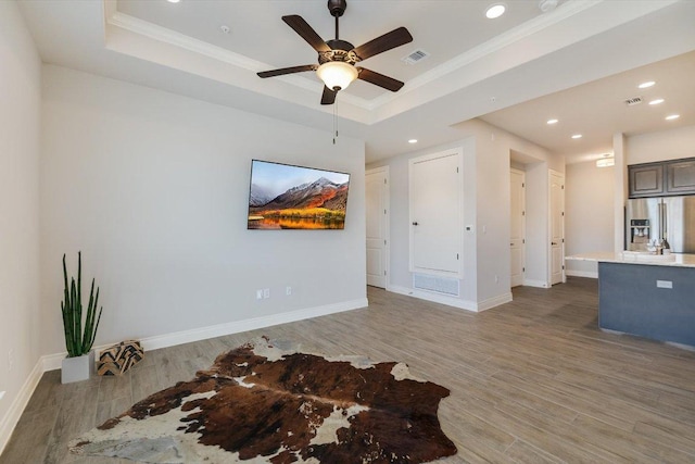 104 Bella Toscana Ave Unit 2301, Lakeway, TX 78734 - unfurnished living room with a raised ceiling, ornamental molding, light wood-style flooring, ceiling fan, and recessed lighting