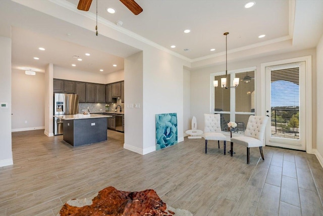 104 Bella Toscana Ave Unit 2301, Lakeway, TX 78734 - living area with light wood finished floors, baseboards, a ceiling fan, a chandelier, and crown molding