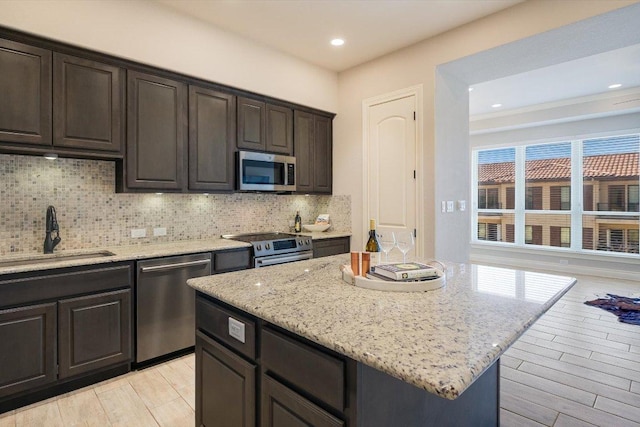 104 Bella Toscana Ave Unit 2301, Lakeway, TX 78734 - kitchen with appliances with stainless steel finishes, a sink, tasteful backsplash, light stone countertops, and recessed lighting