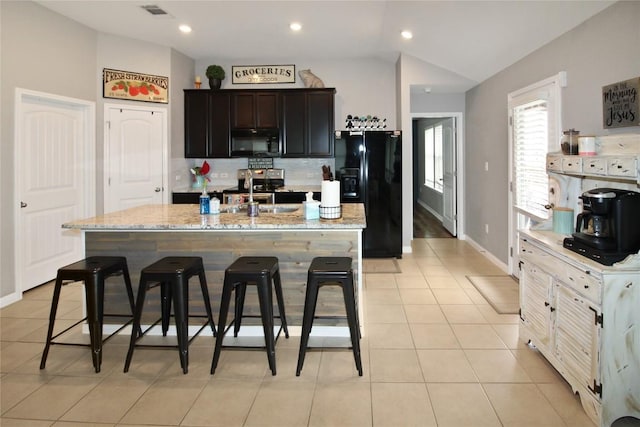 180 Sunshine Ln, Kyle, TX 78640 - kitchen featuring a kitchen breakfast bar, visible vents, vaulted ceiling, light tile patterned floors, and black appliances