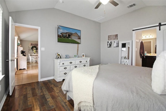 180 Sunshine Ln, Kyle, TX 78640 - bedroom featuring visible vents, a barn door, dark wood finished floors, and lofted ceiling