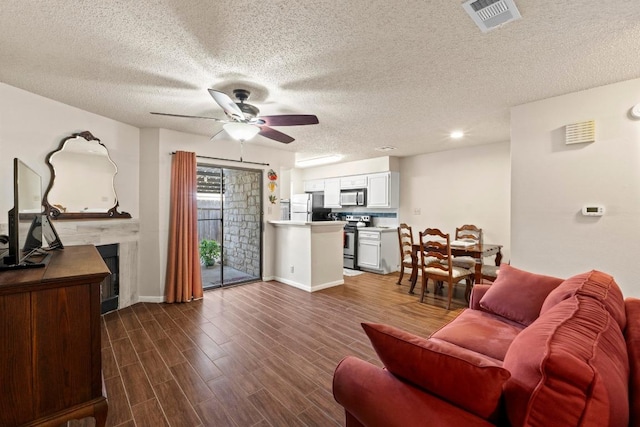 9226 Jollyville Rd Unit 170, Austin, TX 78759 - living room featuring ceiling fan, a fireplace, a textured ceiling, dark wood finished floors, and baseboards